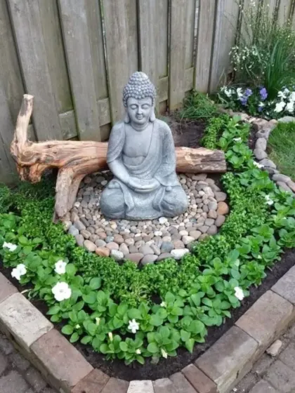 A compact Zen garden perfect for a small corner. I used a brick border to define the space, which features a Buddha statue, river pebbles, and low-growing flowering plants.