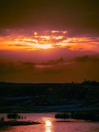 A dramatic sunset over a river. My landscape photography often has a moody, cinematic feel, emphasizing the colors and atmosphere of the sky.