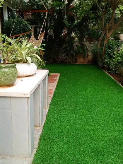 The finished lawn next to a garden bench, creating a perfect, hassle-free relaxation spot.