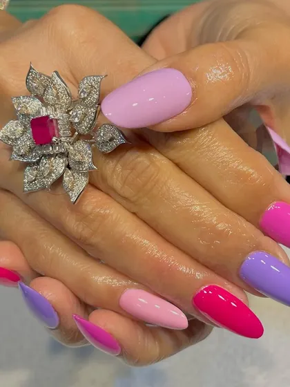 When pink meets purple, the magic happens. This vibrant set features different shades of pink and purple on long, stiletto nails for a bold and playful look.
