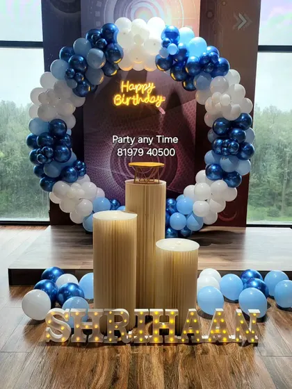 A round arch birthday celebration with blue and white balloons.