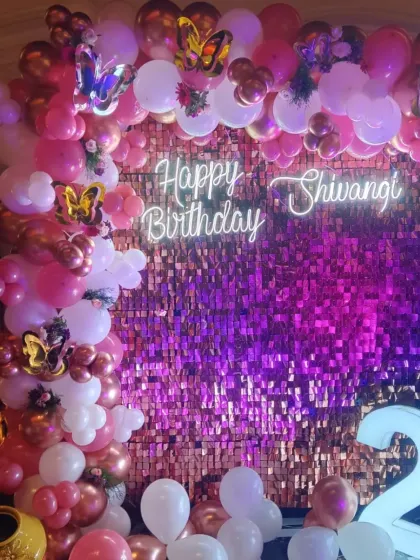 We love a bit of glam! This 21st birthday setup features a vibrant pink and rose gold balloon arch against a sparkling sequin wall, complete with a custom neon sign for that perfect party picture.