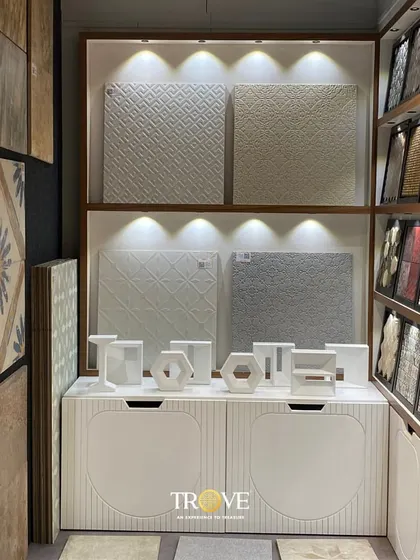 Another view of my showroom's collection. Here, you can see textured white tiles and other decorative pieces, all beautifully lit to highlight their unique patterns and finishes.