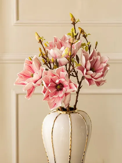 This artificial lotus magnolia stem features delicate pink and white blossoms that look incredibly realistic. It's an ideal choice for adding floral elegance to one of my modern vases.
