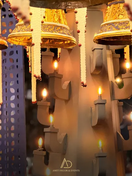 A detailed shot of the lighting, with warm electric candles placed in custom wall sconces and ornate temple bells hanging from the ceiling.