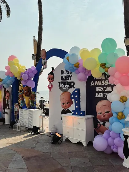 A 'Boss Baby: Mission From Above' party with a beautiful beach backdrop. The setup includes character cutouts and a pastel balloon arch.