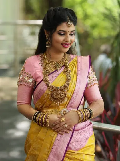 The perfect pairing. The delicate handwork on her pink blouse adds a touch of elegance to her vibrant yellow Kanjivaram saree.