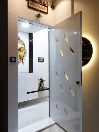 The same safety door shown open, revealing a tranquil interior foyer with a golden Buddha statue. This demonstrates how the entrance design can set the tone for the rest of the home.