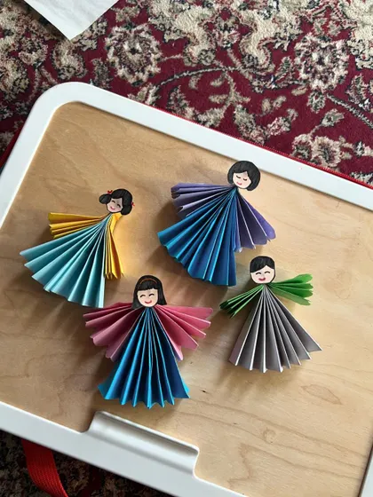 A collection of colorful paper fairies. This simple paper-folding craft is a favorite, and each child adds their own unique touch.