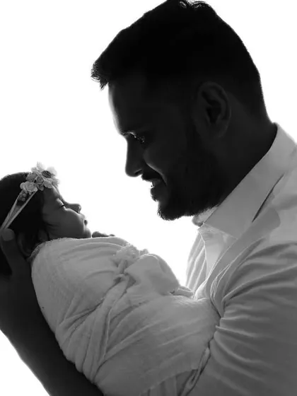 A beautiful high-key silhouette of a father and his newborn. This artistic style creates a simple, powerful, and emotional portrait.