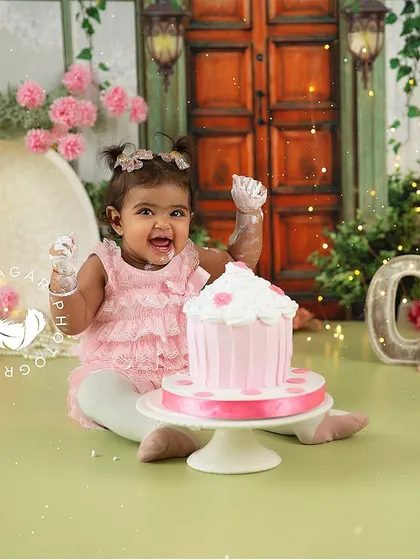 Raising her hands in celebration during her pink-themed cake smash. The joy and energy in this photo are what make these sessions so special.