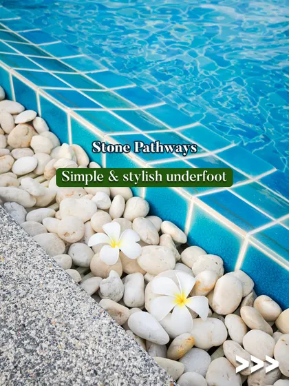 Simple and stylish underfoot, stone pathways are a great addition to any poolside. This close-up shows smooth white pebbles along the edge of a pool, adding a clean and natural texture.