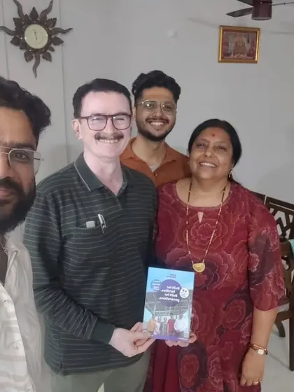 A family poses with our team member, holding our solar guide.