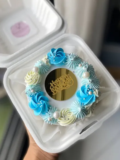 A beautiful blue and white bento cake with a gold "Happy Birthday" charm. The delicate piping and pearl details make this mini cake extra special.