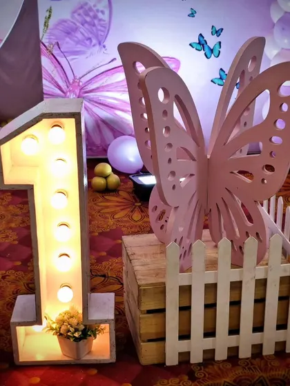 A large light-up number '1' next to a pink butterfly wing prop.