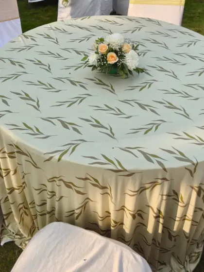 Even the table linens are part of the overall design. This table is covered with a beautiful leaf-patterned cloth, topped with a simple but elegant floral centerpiece for a Haldi lunch.