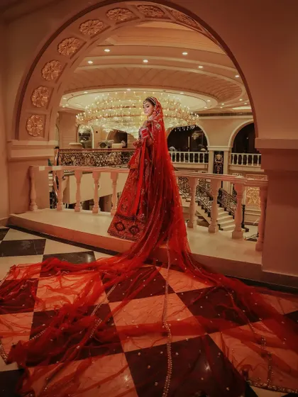 We believe a bride's entrance is a moment of pure magic. This shot captures the grandeur of a bridal lehenga with a dramatic, flowing veil, creating an iconic image that feels like a scene from a fairytale. It showcases our ability to frame monumental moments with an artistic eye.