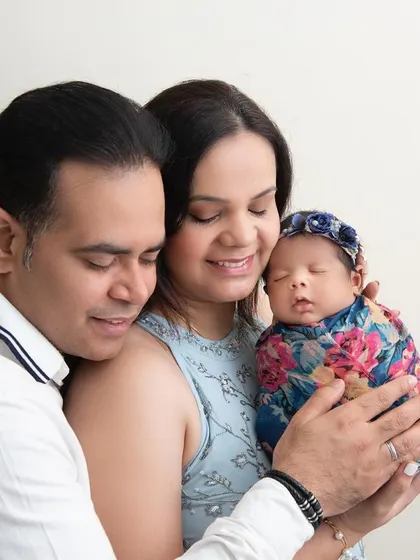 We are family. A simple, classic portrait of new parents holding their greatest treasure. The love and happiness in this photo are palpable.
