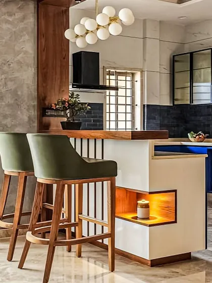 This breakfast counter design is all about unique details, featuring a built-in illuminated niche for display. Paired with elegant olive green bar stools, it creates a stylish and inviting spot for a morning coffee or a casual meal.