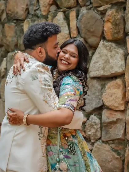 A fun, candid moment of the groom stealing a kiss. These spontaneous shots are often the most cherished, capturing the genuine joy and playfulness of the wedding day.