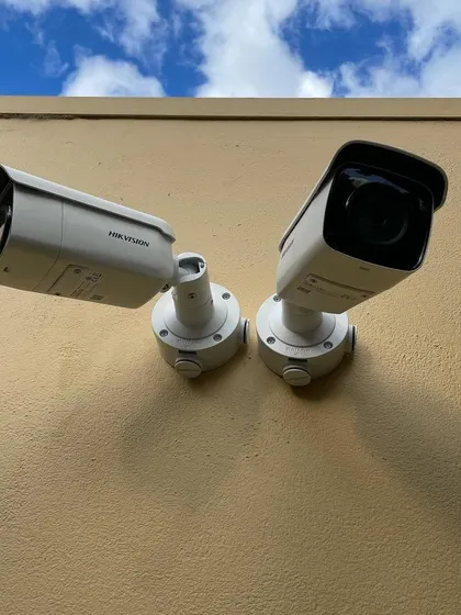 Two Hikvision bullet cameras mounted against a wall, angled to provide wide coverage of an outdoor area. This setup is perfect for monitoring parking lots or the sides of a building.