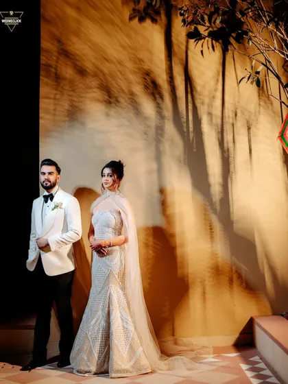 Using creative lighting to cast dramatic shadows on the wall behind the couple. This artistic technique adds texture and visual interest to a formal portrait, turning it into a unique piece of art.