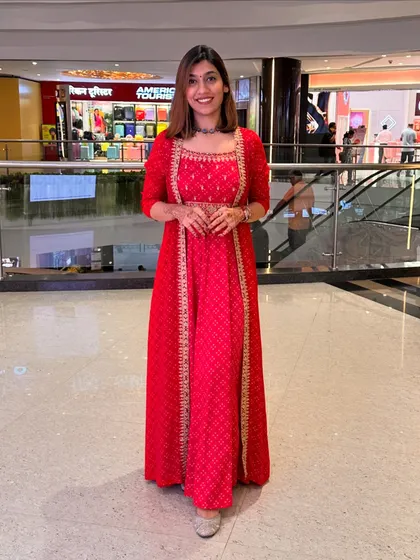 A full-length shot of the red Anarkali set, showcasing its beautiful flare and elegant silhouette in a mall setting.