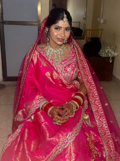 A full view of this gorgeous bride in her pink wedding lehenga. The makeup is soft and radiant, letting her natural happiness be the focus.