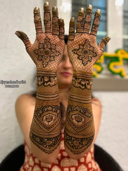 A symmetrical design with a central mandala on the palm, surrounded by intricate patterns. The fingertips are kept dark for a traditional look.