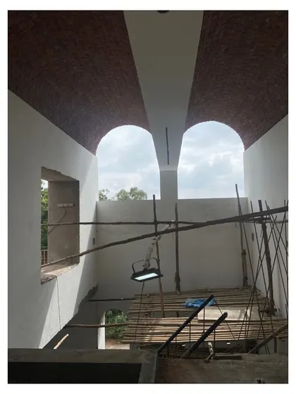 The building's structure seen without its final skin, revealing the interplay between the random rubble masonry and the exposed brick volumes.