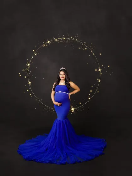 A regal portrait in royal blue. The sparkling ring of light and elegant tiara add a celestial, queenly touch to this stunning maternity photo.