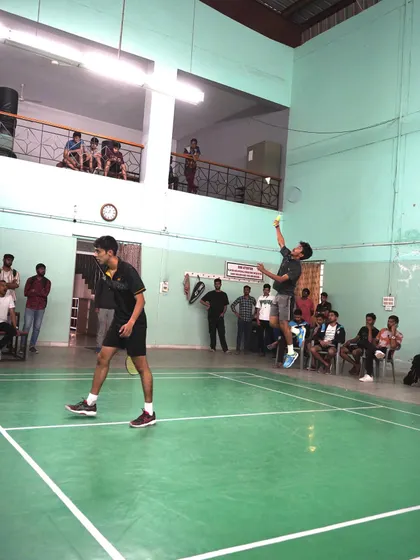 A doubles match in progress, with a player airborne for a smash. Teamwork and positioning are key elements of our doubles strategy sessions.