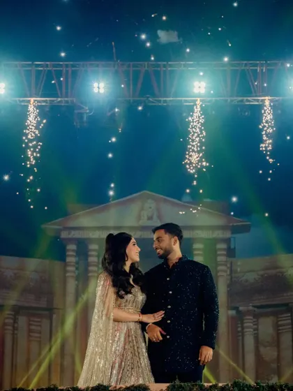 An intimate moment for the couple on stage, framed by spotlights and a gentle cascade of sparklers. Even amidst the grandeur, I strive to create moments of personal connection.