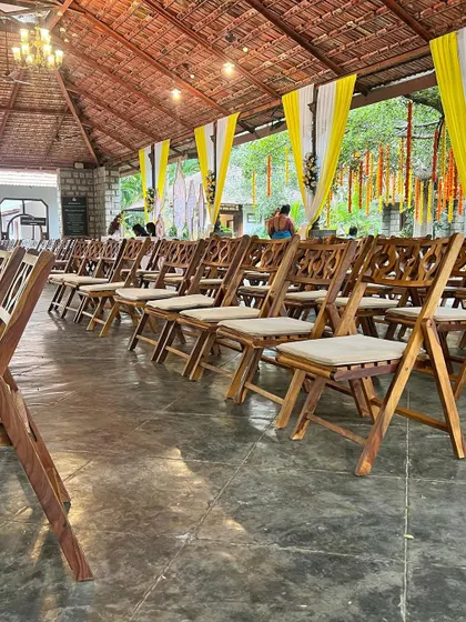 The seating arrangement for a traditional ceremony, featuring elegant wooden chairs with intricate carvings, ready for the guests.