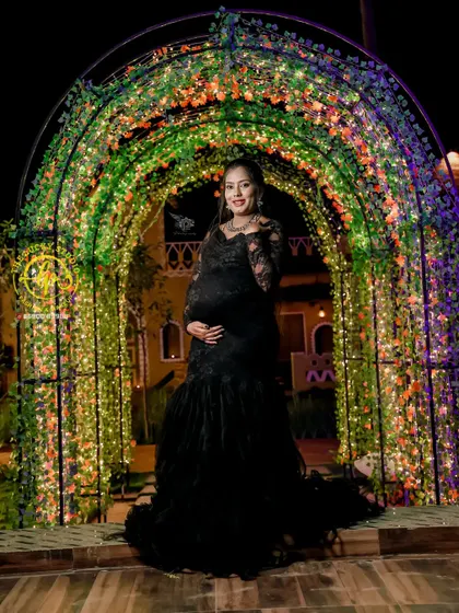 A magical maternity portrait under a lighted archway. The all-black lace gown creates a look of pure elegance and sophistication for the mother-to-be.