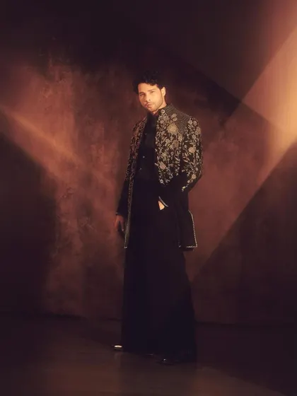 A full-length view of Siddhant's Diwali ensemble. The longline jacket paired with tailored trousers creates a sleek, contemporary ethnic silhouette.