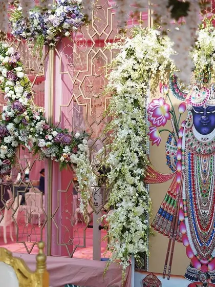 A detail of the mandap backdrop, featuring a beautiful Pichwai painting of Shrinathji, framed by cascading white florals. We love incorporating personal and spiritual elements into our designs.