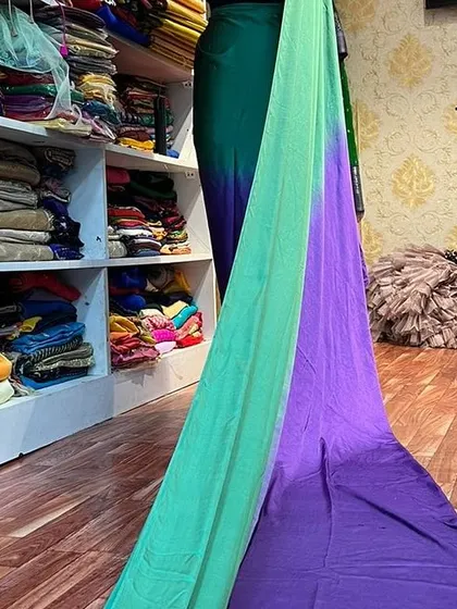 A glimpse of our dual-toned green and purple long trail saree on display in the store.