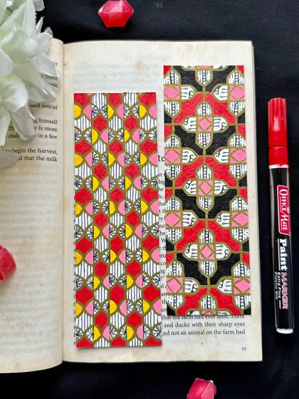 Good things are coming. A pair of bookmarks with intricate geometric patterns in red, pink, yellow, and black.