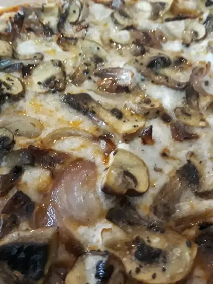 Another angle of the mushroom and onion pizza, highlighting the savory toppings on a gluten-free base.