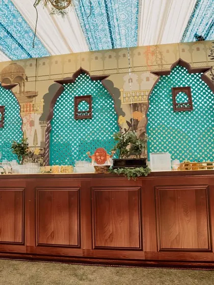 The buffet station, featuring a backdrop of painted arches and jaali screens. The design ensures that every part of the event space, including the food service area, is thematically integrated.
