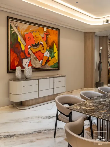 Art is central to our design philosophy. Here, a large, vibrant Ganesha painting becomes the focal point of the dining area, beautifully complementing the modern credenza and elegant dining set.