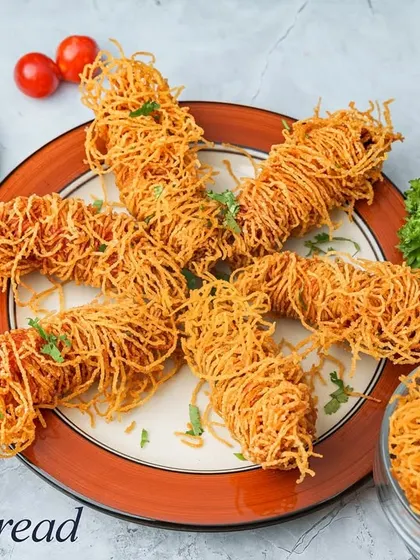Crispy Thread Chicken involves wrapping seasoned chicken in thin pastry threads or noodles and deep-frying them until golden brown. The result is an incredibly crunchy exterior with a juicy center.