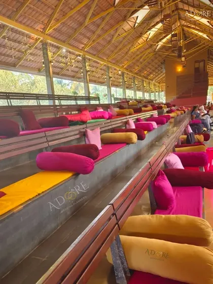 Comfortable and vibrant seating for guests at an outdoor wedding. The colorful cushions and bolsters not only provide comfort but also add a splash of color to the venue's amphitheater-style seating.