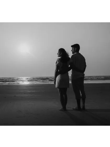 A classic black and white portrait of the couple looking out at the sunset. It's a timeless and contemplative image.