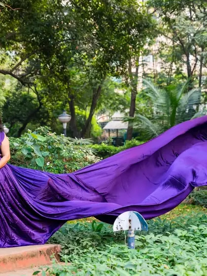 A dramatic and powerful shot showcasing a vibrant purple gown with a long, flowing train. This kind of image is perfect for clients who want a bold and artistic maternity portrait.