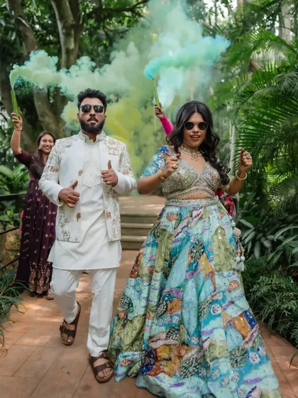 A cool and stylish entrance with colorful smoke bombs. This shot perfectly captures the couple's modern vibe and the fun atmosphere of their pre-wedding event.