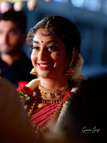 This candid shot captures the bride's radiant smile. The makeup is designed to look fresh and natural, with a pop of color on the lips to brighten her entire face.