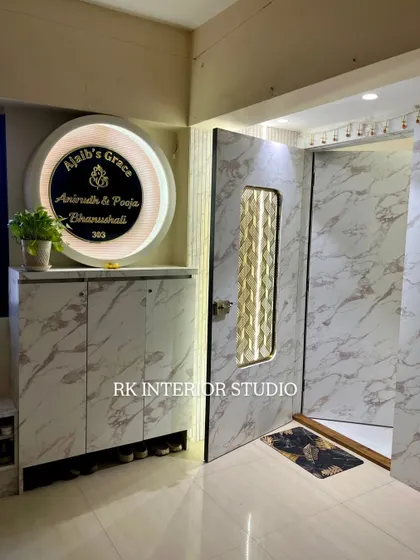This elegant entrance features a marble-laminate finish on the door and shoe cabinet. The large, circular backlit nameplate adds a personalized and luxurious touch.