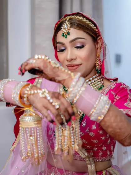 Getting her final touches. The pink tones in her makeup and outfit created such a harmonious and beautiful bridal look.